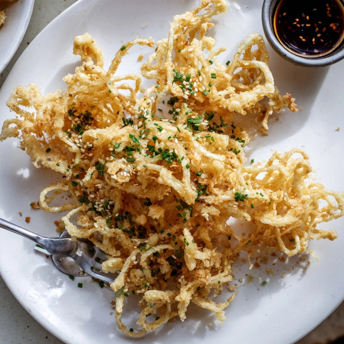 Savory Crispy Enoki Mushroom appetizer, light batter creating delicious texture served with dipping sauce.