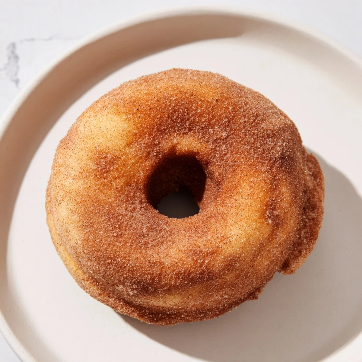 Freshly baked Baked Apple Cider Donuts with a soft, spiced interior and a buttery, sweet topping.