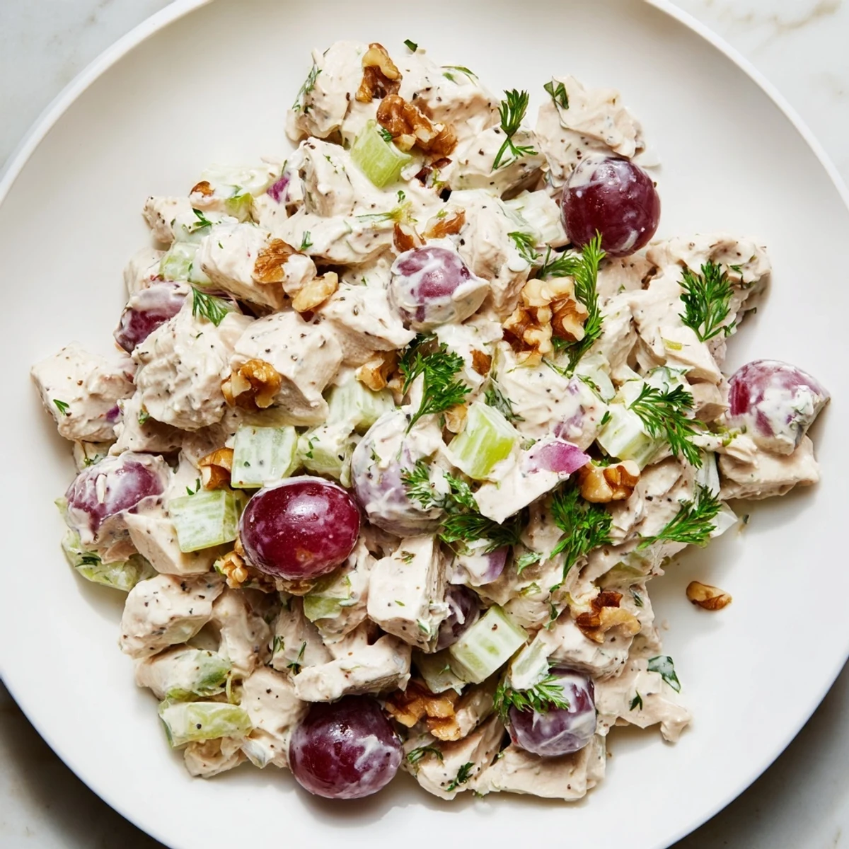 Freshly assembled creamy chicken salad, vibrant with grapes, offers a cool, refreshing lunch.