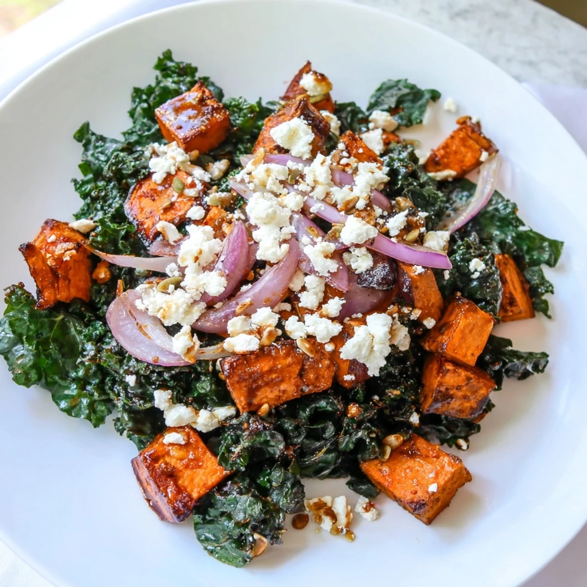 Earthy sweet potato and kale salad brightened with creamy feta and a tangy dressing.