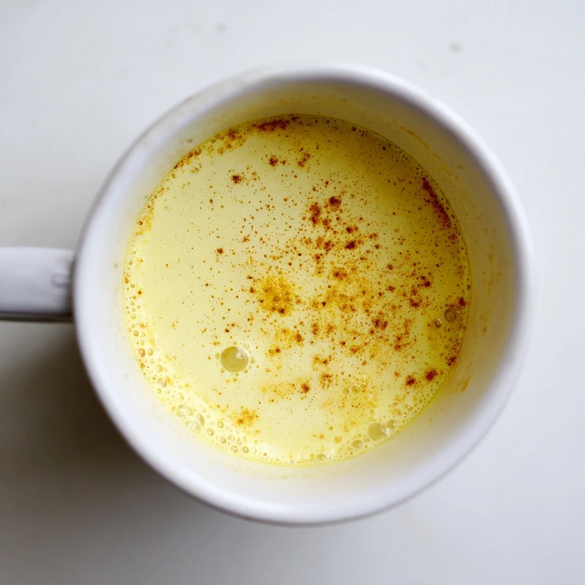 Steaming mug of Golden Milk, a creamy, spiced beverage, perfect for a cozy night.