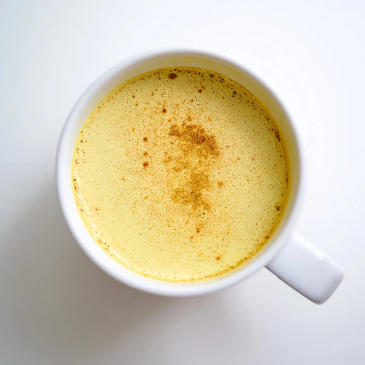 Warm, golden-hued Golden Milk, topped with cinnamon, offering comfort in every sip.