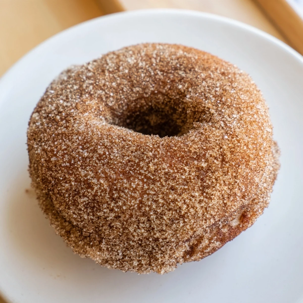 Golden-brown Cider Donuts glistening with cinnamon sugar, ready to enjoy with a warm drink.