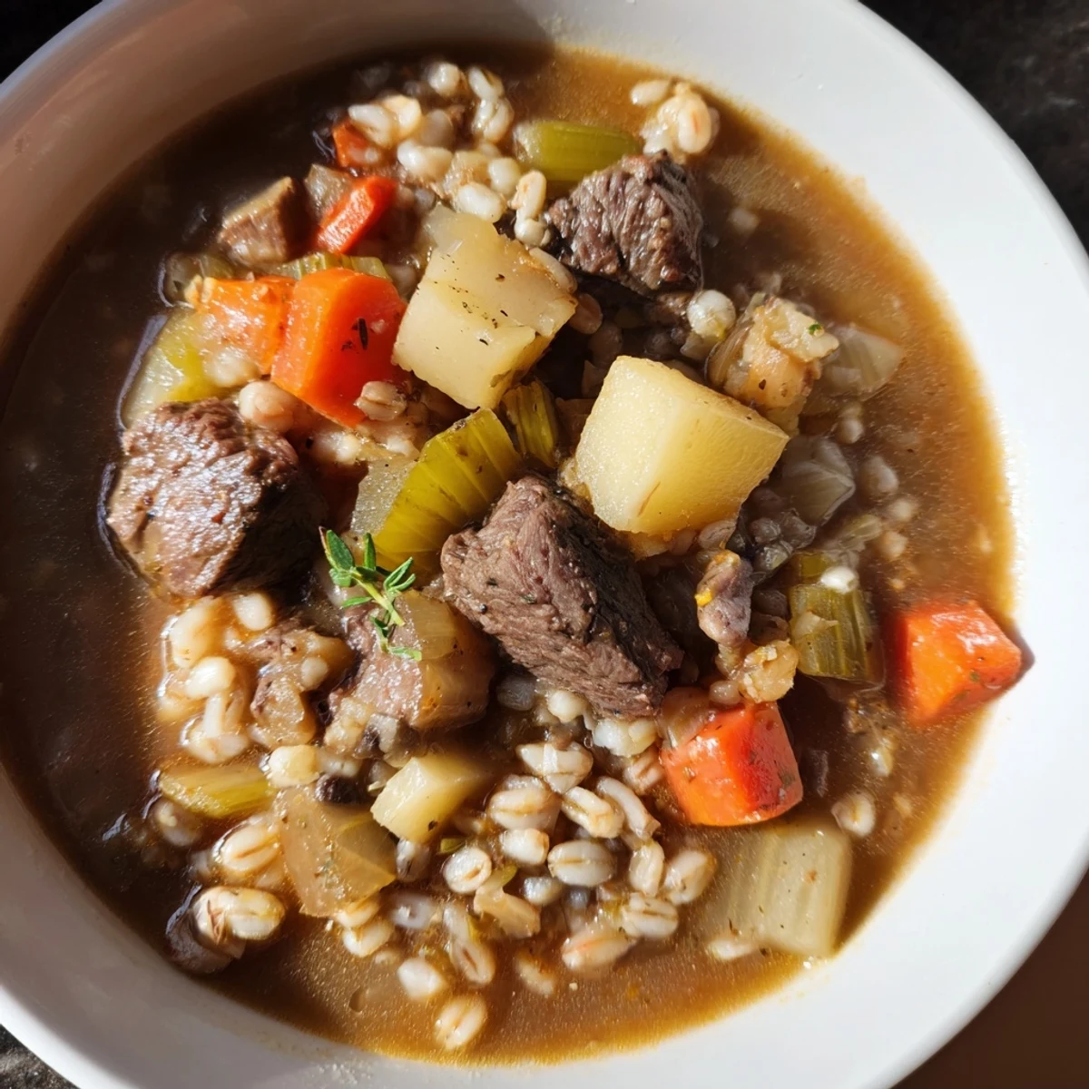 A steaming bowl of Hearty Beef and Barley Soup, garnished with fresh parsley, awaits.