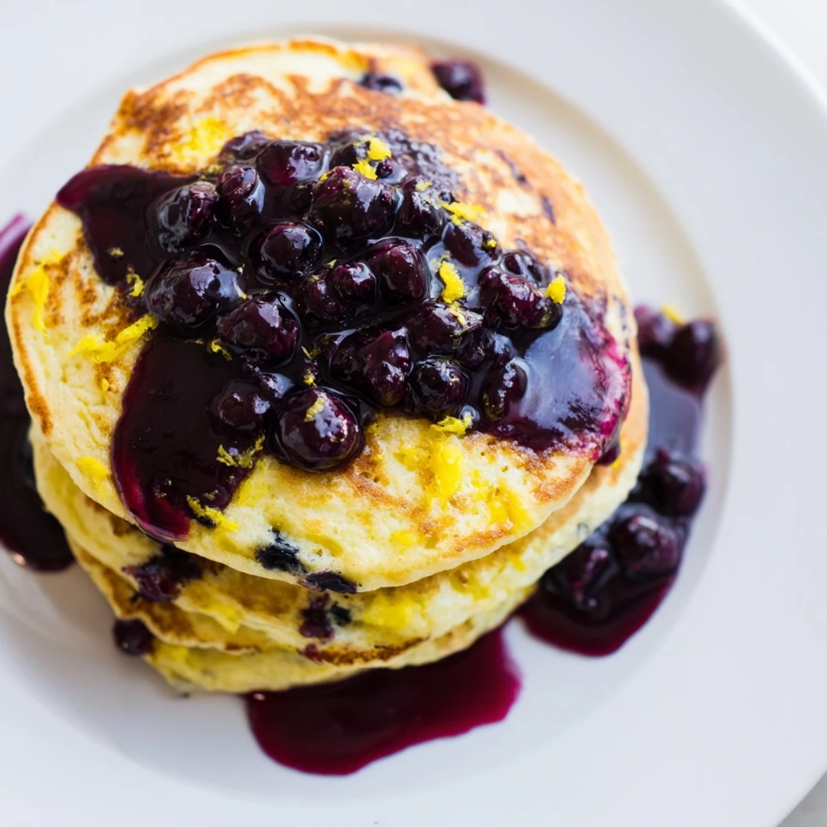 Freshly made Lemon Ricotta Pancakes, featuring a bright lemon zest aroma, and juicy blueberries.