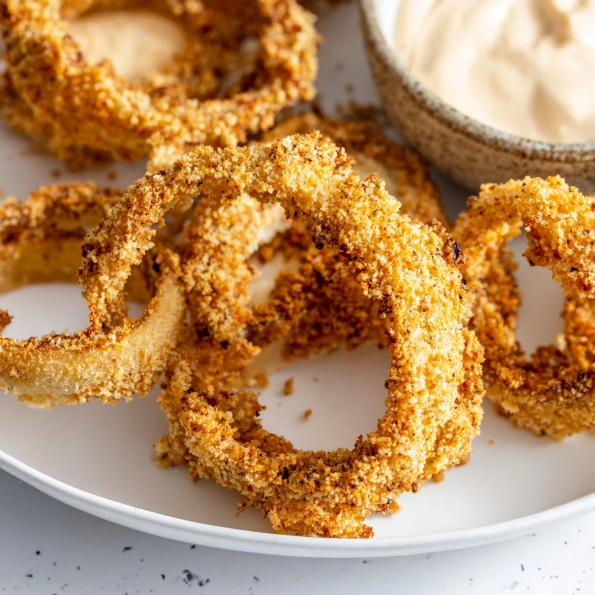 Close-up of golden, crunchy air fryer onion rings, offering a satisfying bite with every crunch.
