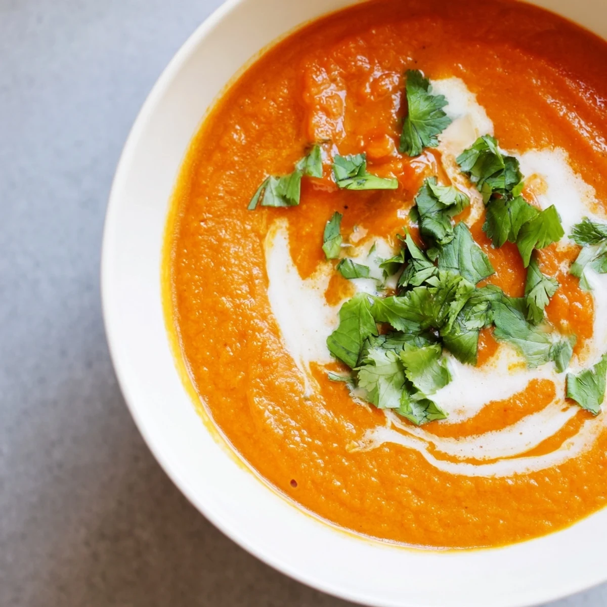 A vibrant pot of Roasted Red Pepper and Sweet Potato Soup simmering on the stove with steam rising.