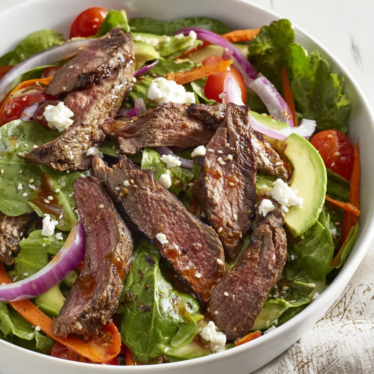 Freshly seared beef strips rest on crisp romaine and spinach in this Beef Salad Bowl, topped with creamy avocado and drizzled with balsamic dressing.