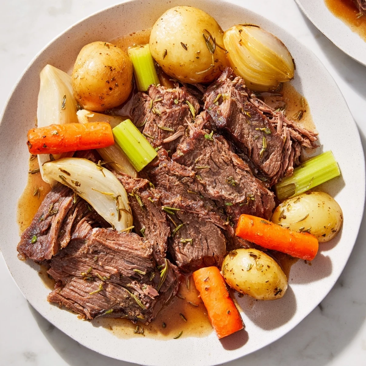 Family-style Slow Cooker Pot Roast with Carrots, garnished with fresh thyme and surrounded by colorful vegetables.