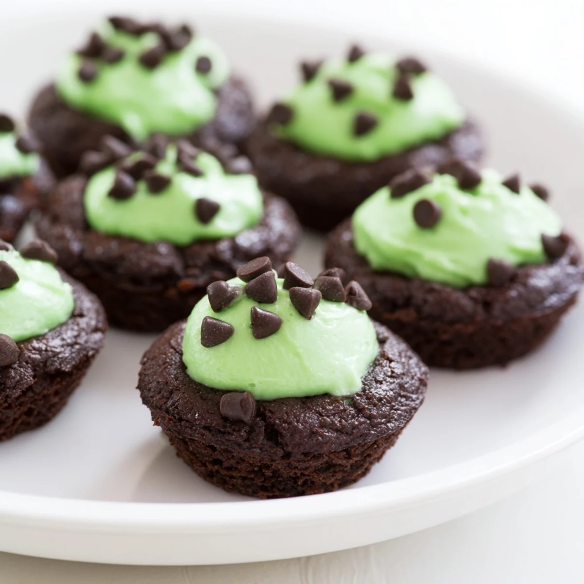 Close-up of St. Patricks Day Mint Brownie Bites revealing a moist, chocolatey crumb and glossy green peppermint frosting.