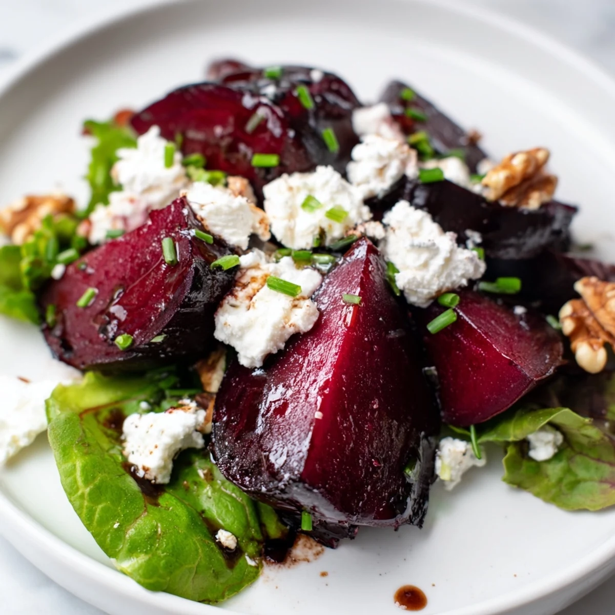 Roasted Beet and Goat Cheese Salad with Walnuts arranged on a platter with bright pink beets, creamy crumbles, and toasted nuts, drizzled with vinaigrette.