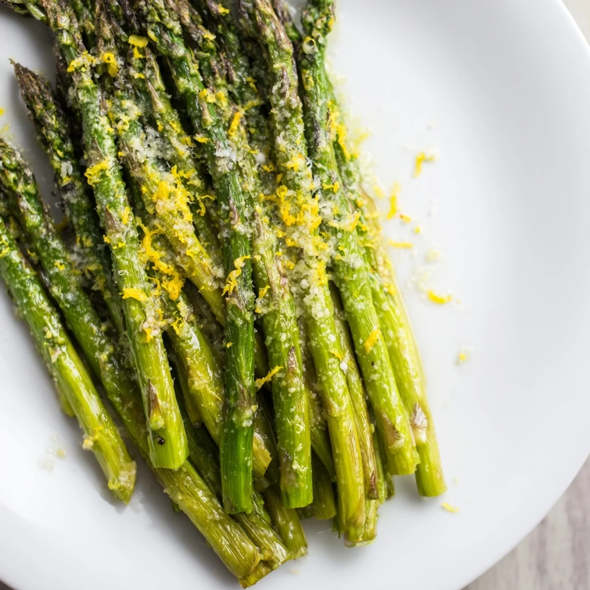 Fresh roasted asparagus with Parmesan and lemon, garnished with zest and cheese, ideal for a Mediterranean diet meal.