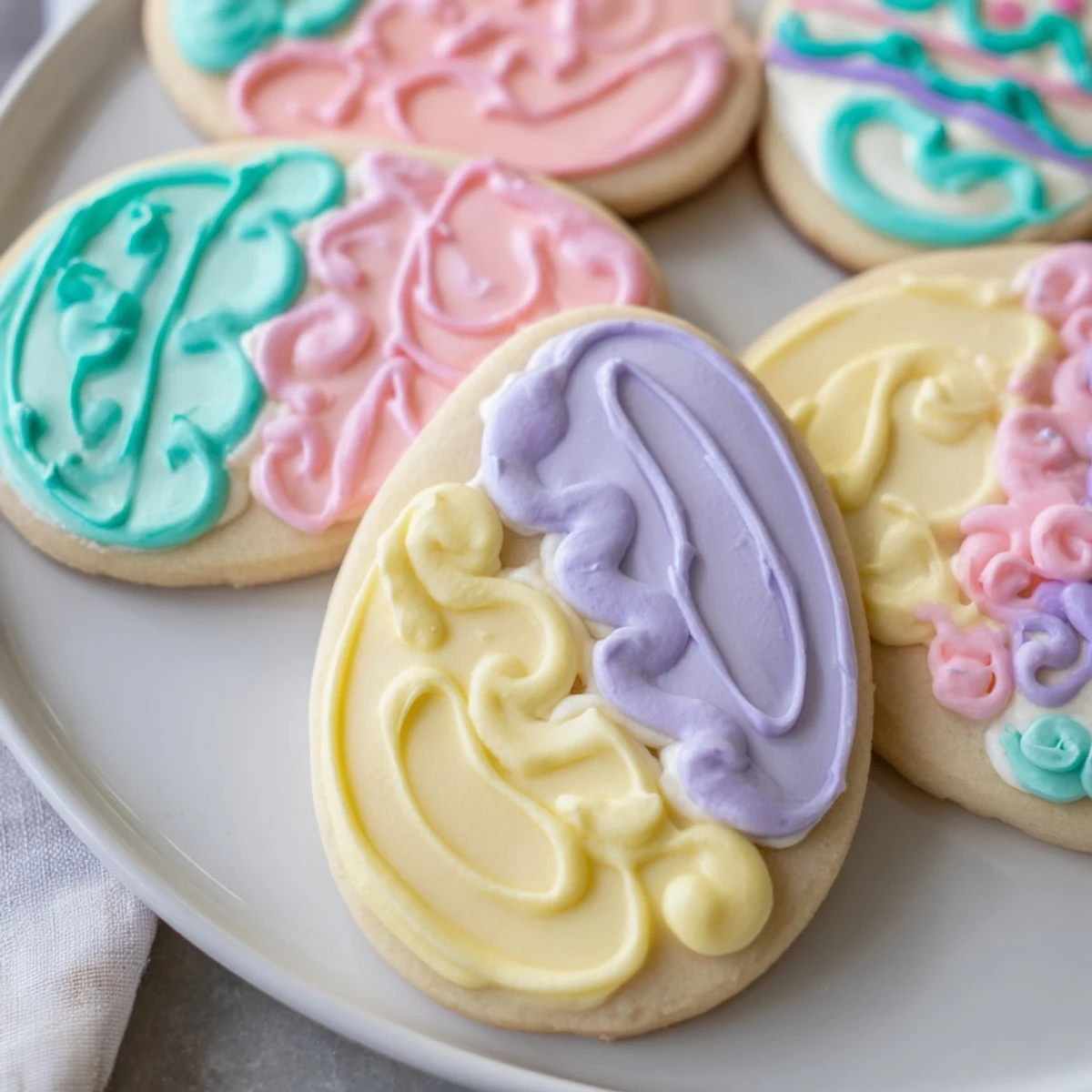 Freshly decorated Easter Egg Sugar Cookies show glossy pastel icing and crisp edges on a clean marble surface.