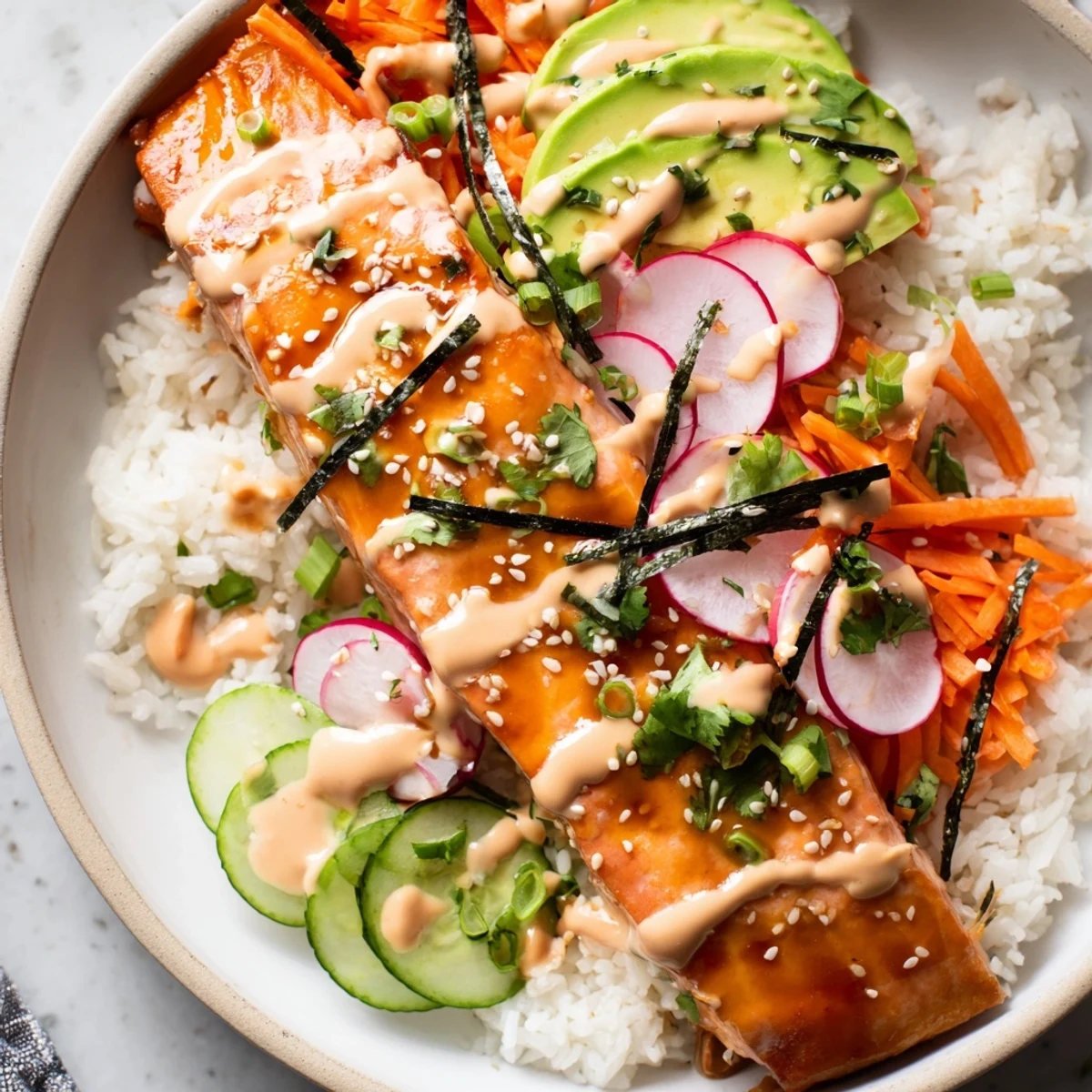 Tender teriyaki salmon glazed in a sweet soy sauce rests atop fluffy jasmine rice in these vibrant bowls.