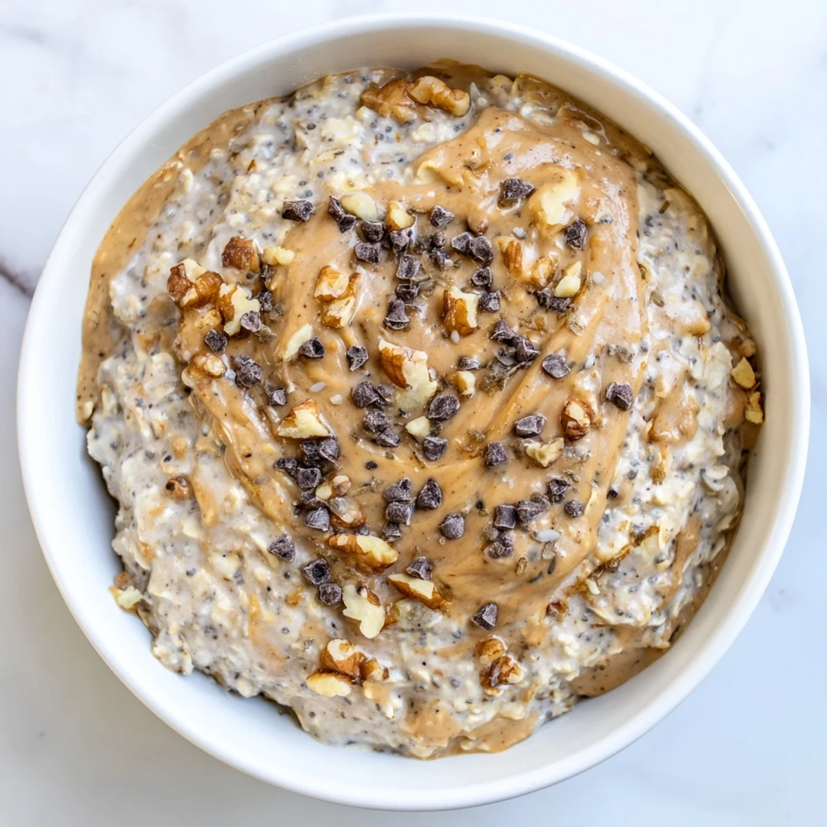 Overnight oats in a jar featuring creamy cookie dough flavors, chocolate chips, and a nutty swirl ready for a hearty American breakfast.