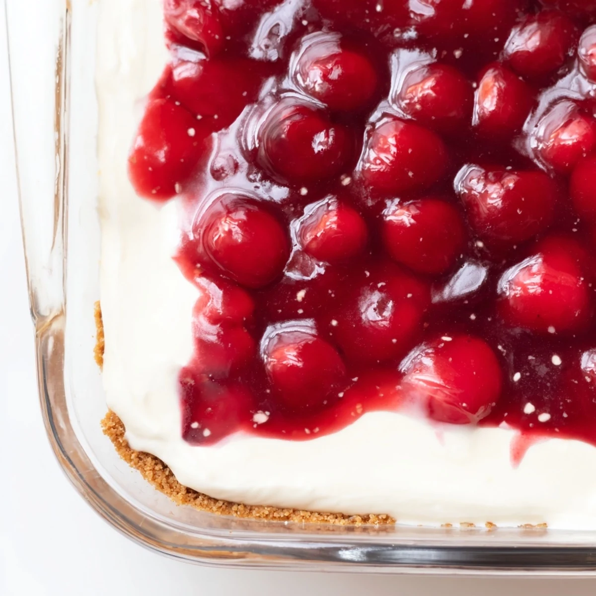 Overhead view of Classic Cherry Delight served chilled in a baking pan, ready to be cut into squares for a summer potluck.