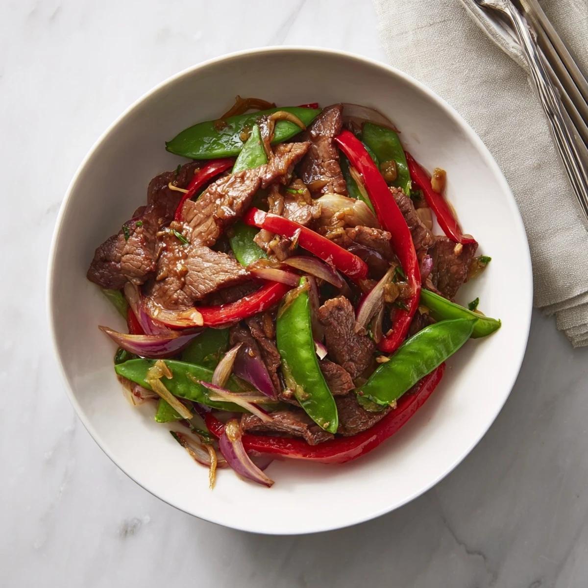 Tender beef and crisp red bell peppers coated in glossy oyster sauce in a hot wok.