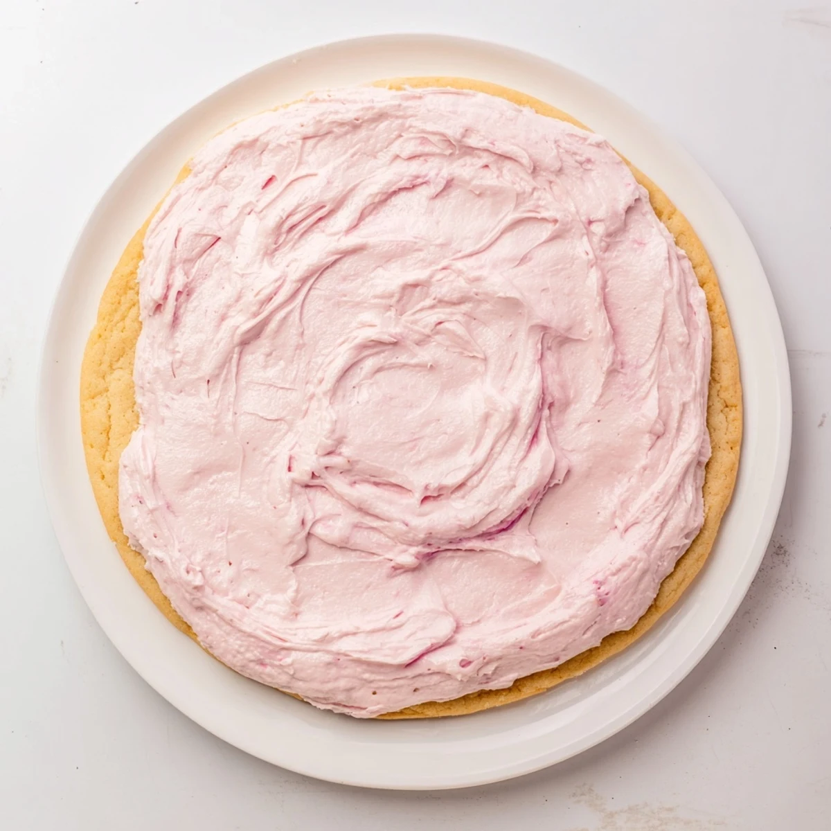 A plated Giant Chilled Crumbl Sugar Cookie with frosting melting slightly, ready to be served as a chilled bakery-style dessert.