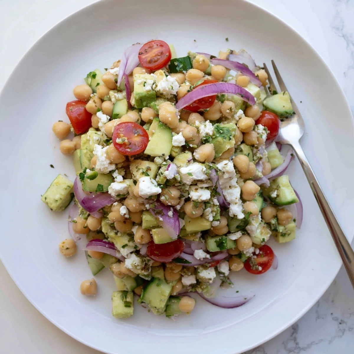 Crisp cucumber and cherry tomatoes pair with hearty chickpeas in this vibrant Chickpea Feta Avocado Salad.