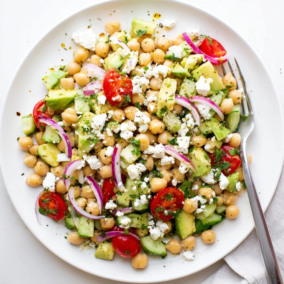 Creamy avocado and tangy feta shine in this Chickpea Feta Avocado Salad with fresh veggies.