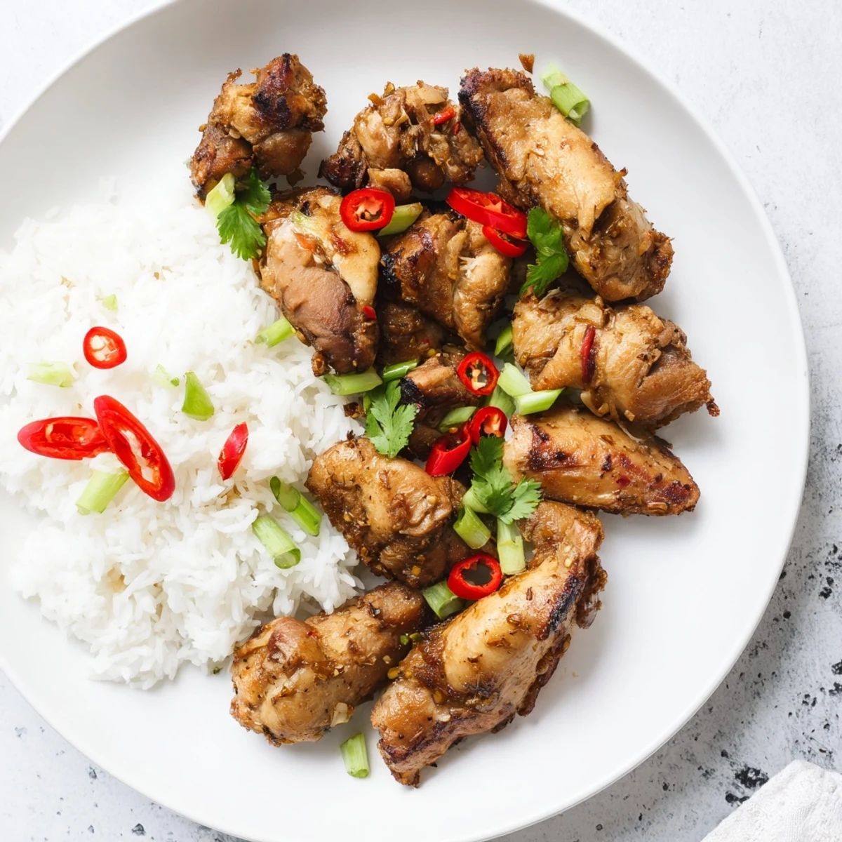 Vietnamese Lemongrass Chicken served over fluffy rice with fresh cilantro and chili slices