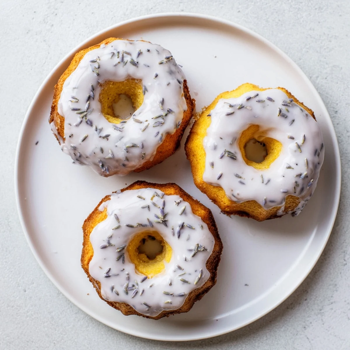 Teatime spread featuring bite-sized lemon cakes with sweet lavender glaze and scattered lavender buds