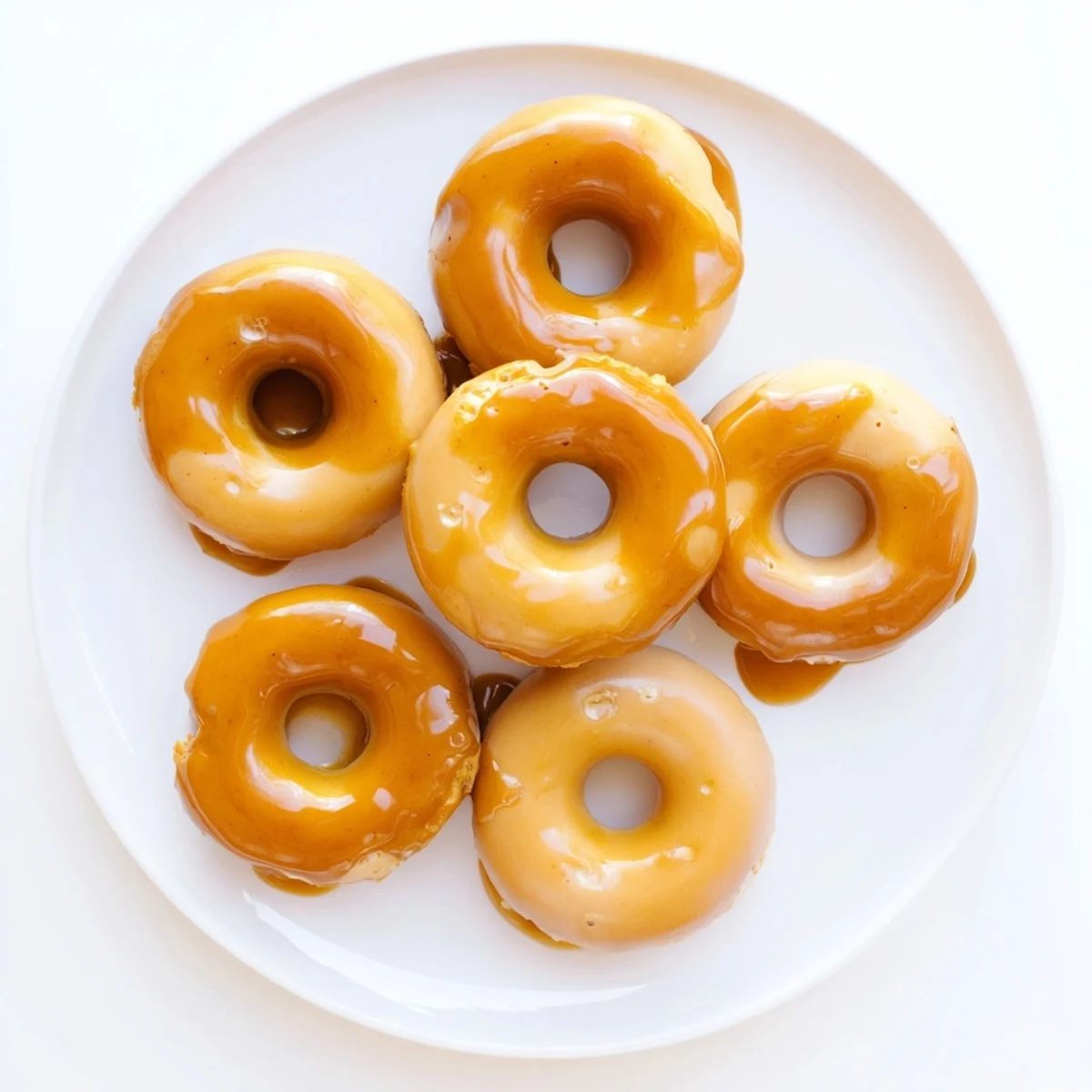 Soft pumpkin mochi donuts with dripping maple frosting and toasted pecans