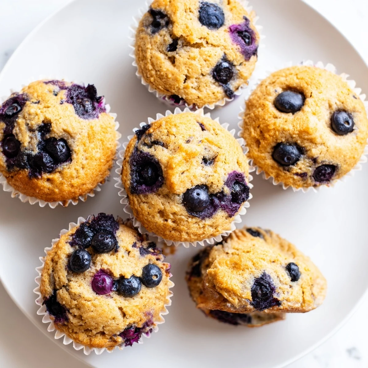 Gluten-free almond flour blueberry muffins with Greek yogurt topped with fresh blueberries and lemon zest