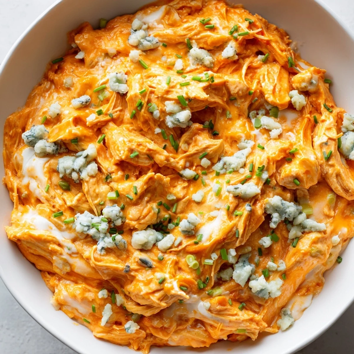 Creamy Crockpot Buffalo Chicken Dip bubbling with melted cheddar and mozzarella cheese
