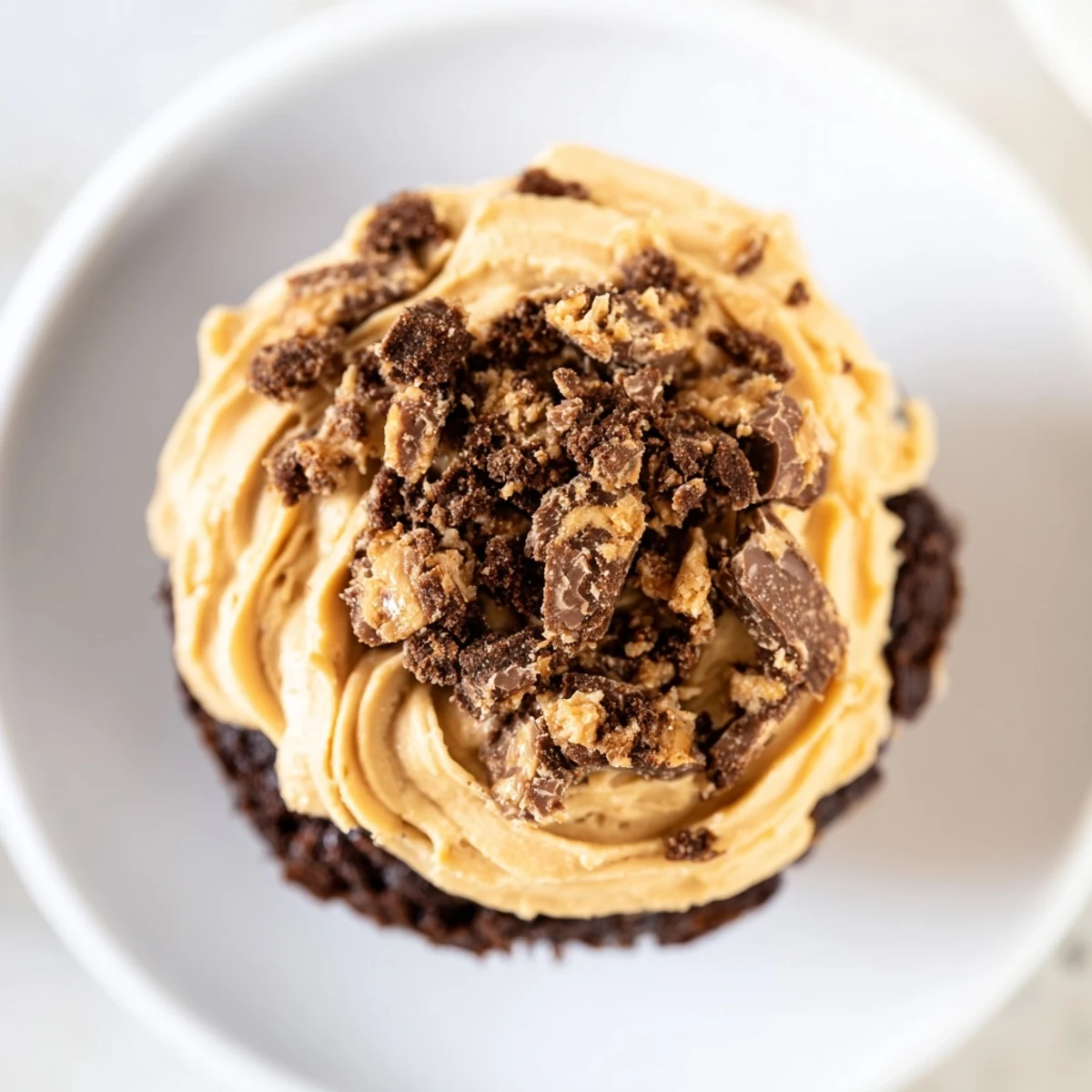 Rich chocolate Decadent Butterfinger Cupcakes topped with fluffy peanut butter frosting and crunchy candy pieces