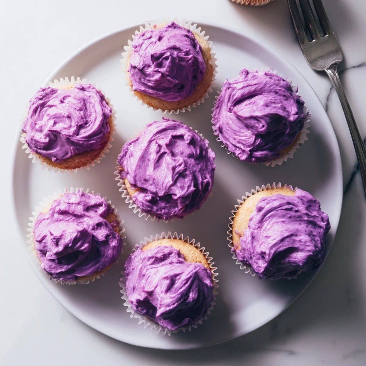 Fluffy grape soda cupcakes with vibrant purple frosting and colorful sprinkles for parties