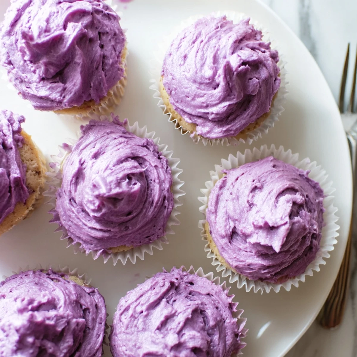 Close-up of moist grape soda cupcakes with tangy grape buttercream and decorative garnish