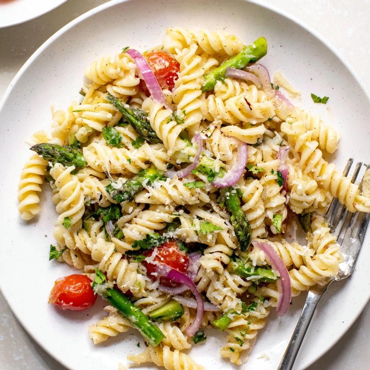 Refreshing lemon asparagus pasta salad plated outdoors for warm weather entertaining and potlucks