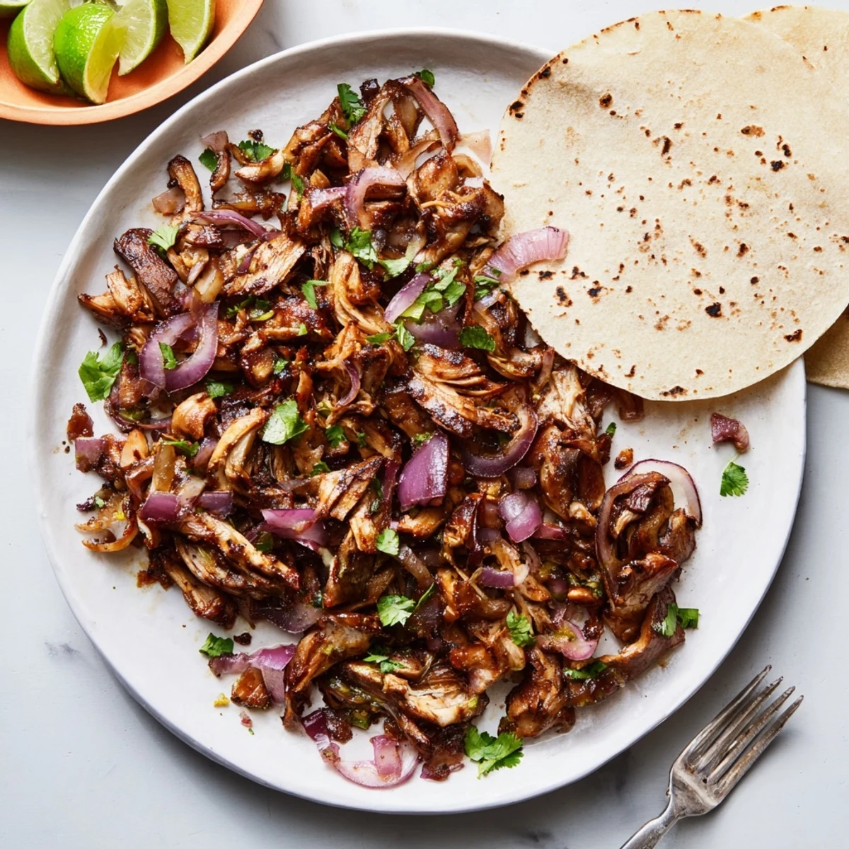 Spicy mushroom carnitas tacos topped with fresh cilantro, diced onion, and lime