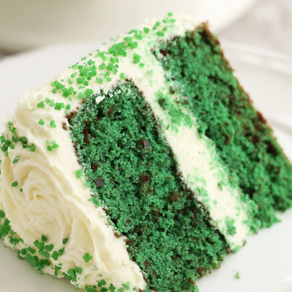 Green Velvet Cake with creamy frosting displayed on a white cake stand
