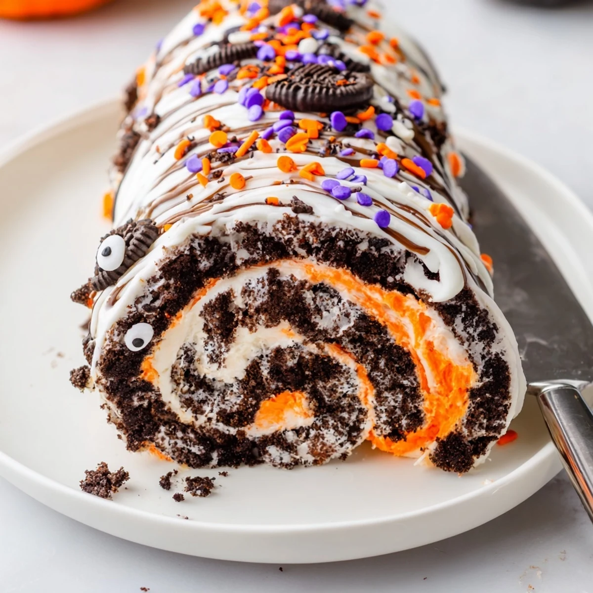 No-bake Halloween Oreo Roll with vibrant orange whipped filling and festive sprinkles on a platter.