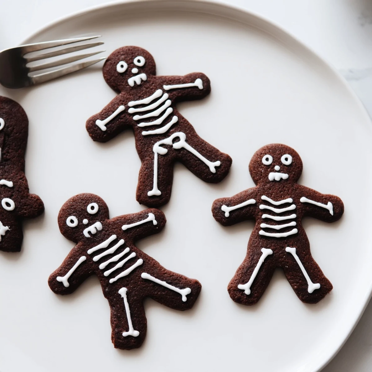 Warm spiced Chocolate Cinnamon Skeleton Cookies decorated with intricate royal icing bone designs