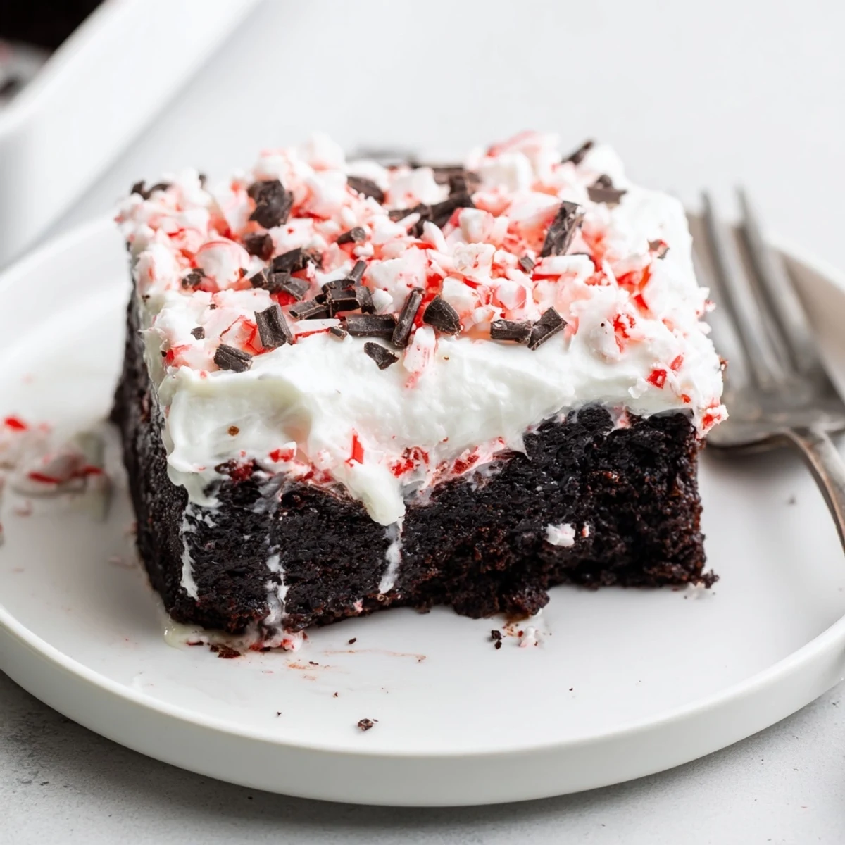 Sliced Peppermint Poke Cake showing moist chocolate crumb poked and filled.