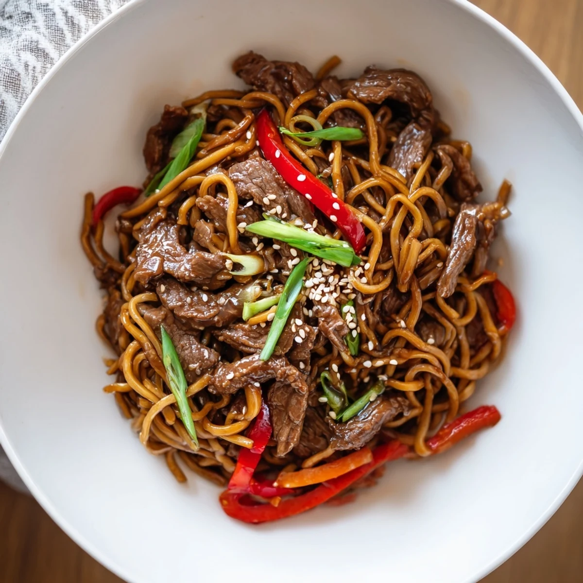Weeknight Sticky Beef Noodles tossed in sweet and savory sauce, sprinkled with sesame seeds