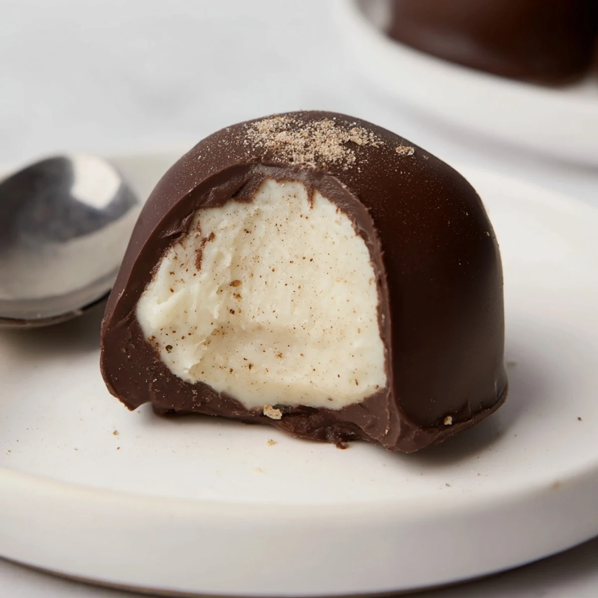 Dark Chocolate Eggnog Truffles arranged on parchment, glossy shells dusted with nutmeg.