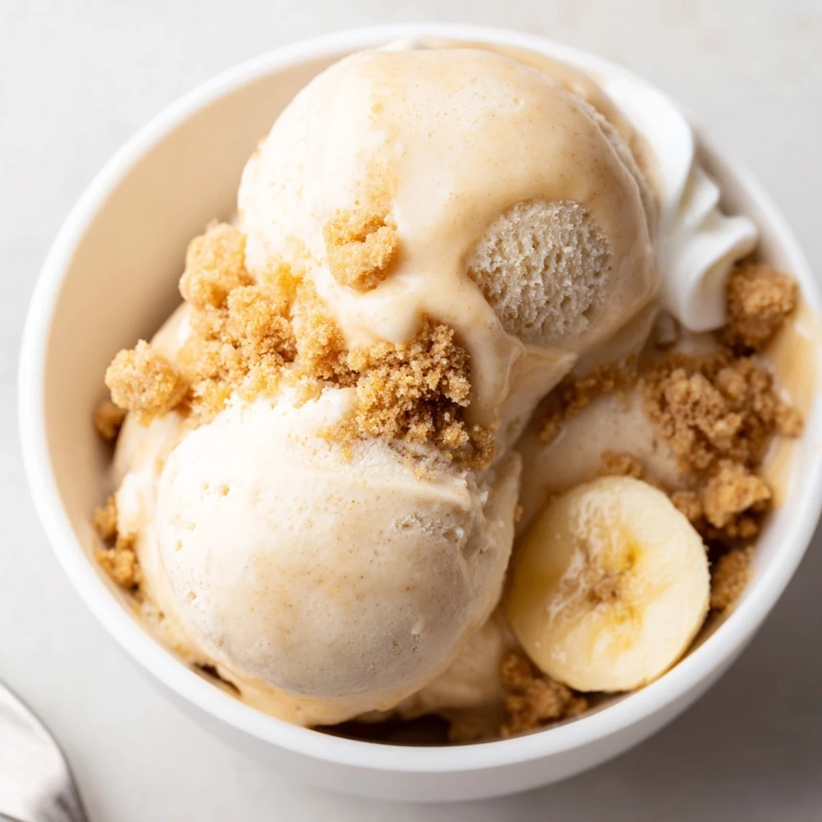 Freshly churned bowl featuring Ninja Creami Banana Cream Pie Ice Cream with bananas