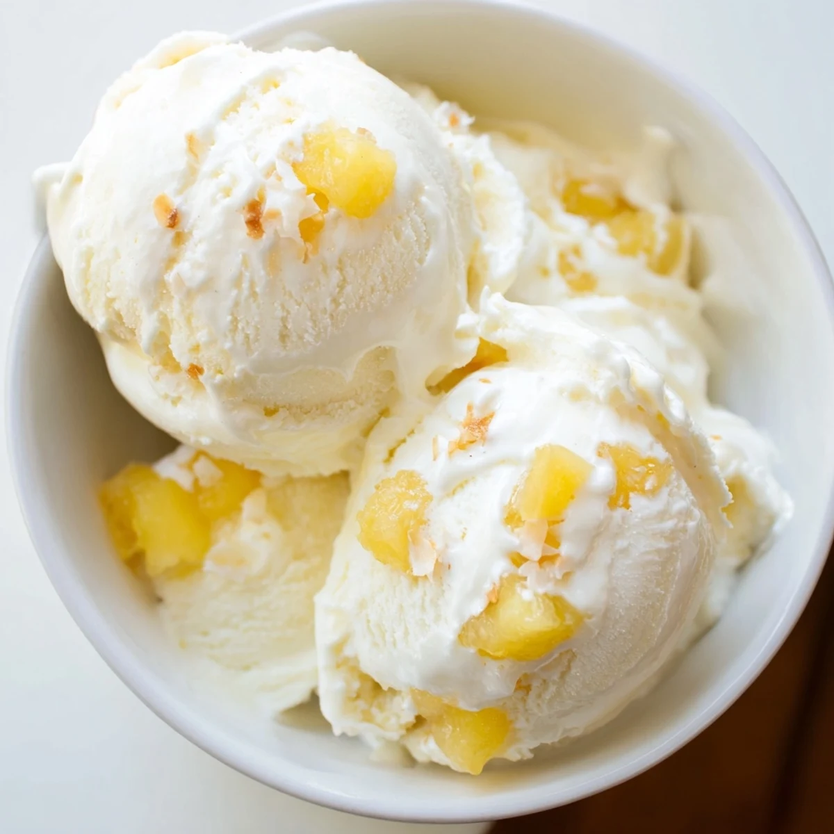 Homemade Creamy Pineapple Ice Cream cooling in freezer-safe container, tropical aroma