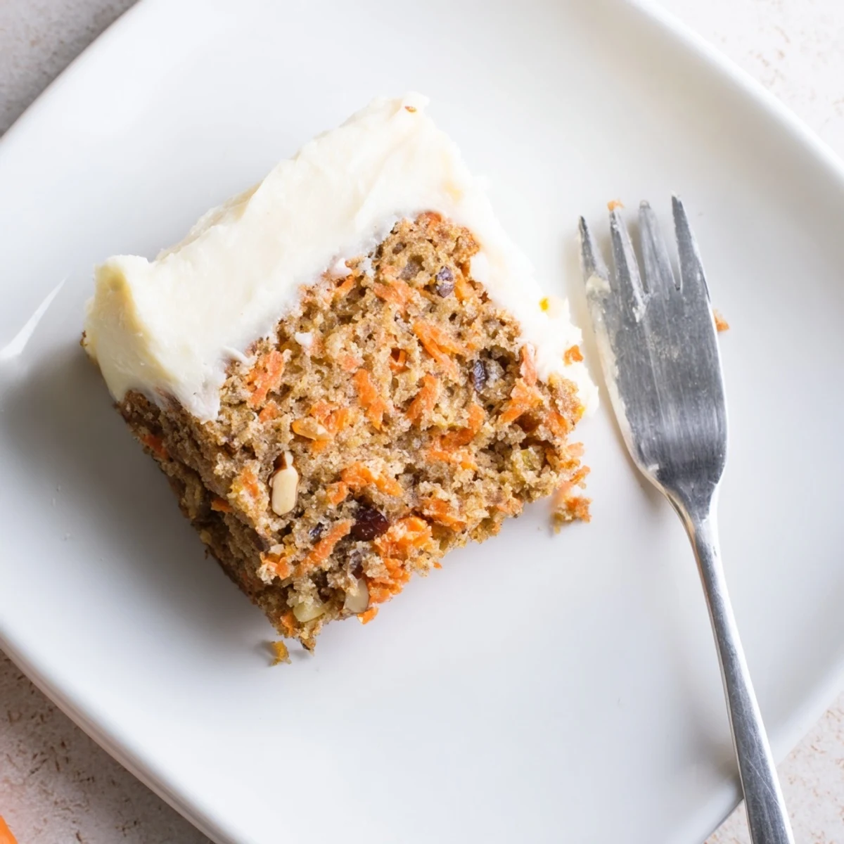 Moist gluten-free carrot cake with visible grated carrot pieces and a dusting of cinnamon