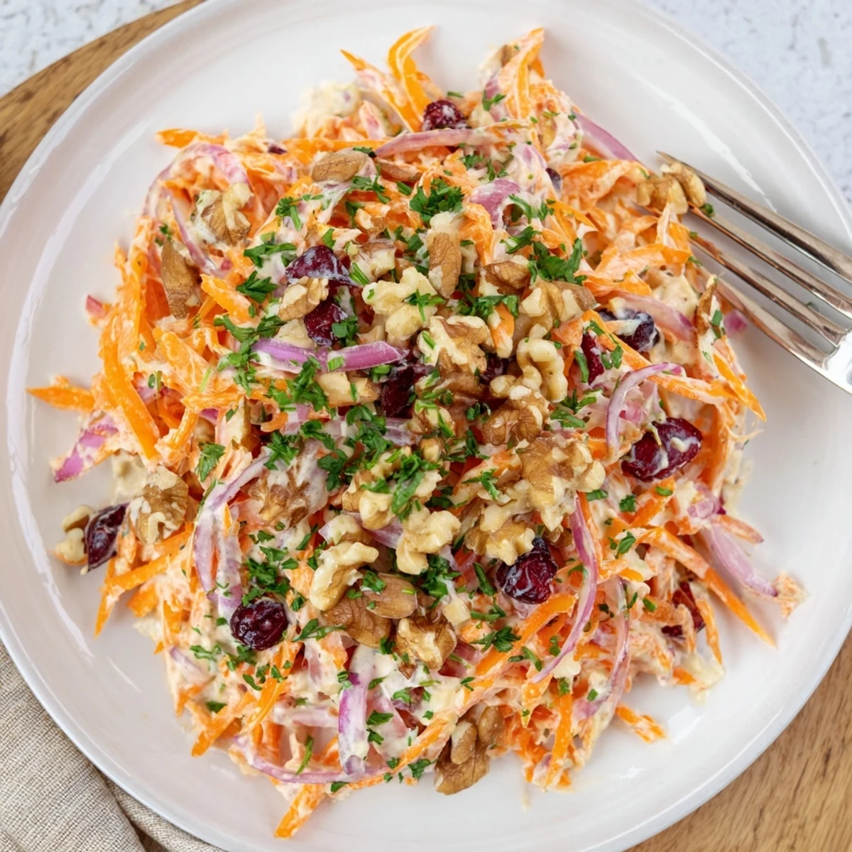 Fresh apple carrot slaw with crisp julienned vegetables in creamy yogurt dressing
