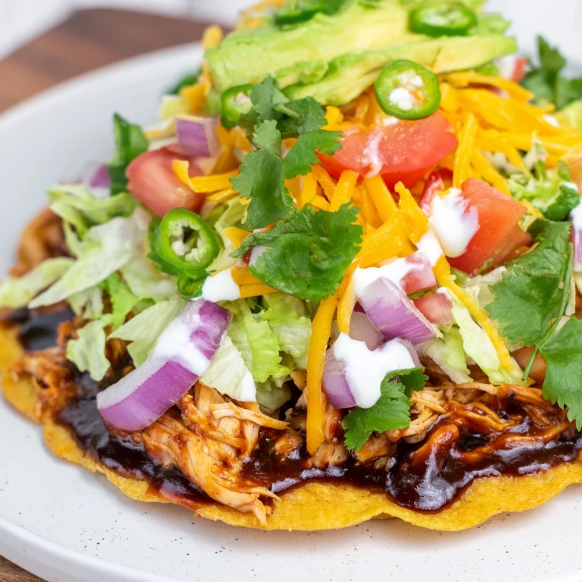 Golden tostada shells loaded with tender sweet smoky BBQ chicken, creamy avocado slices, and tangy sour cream