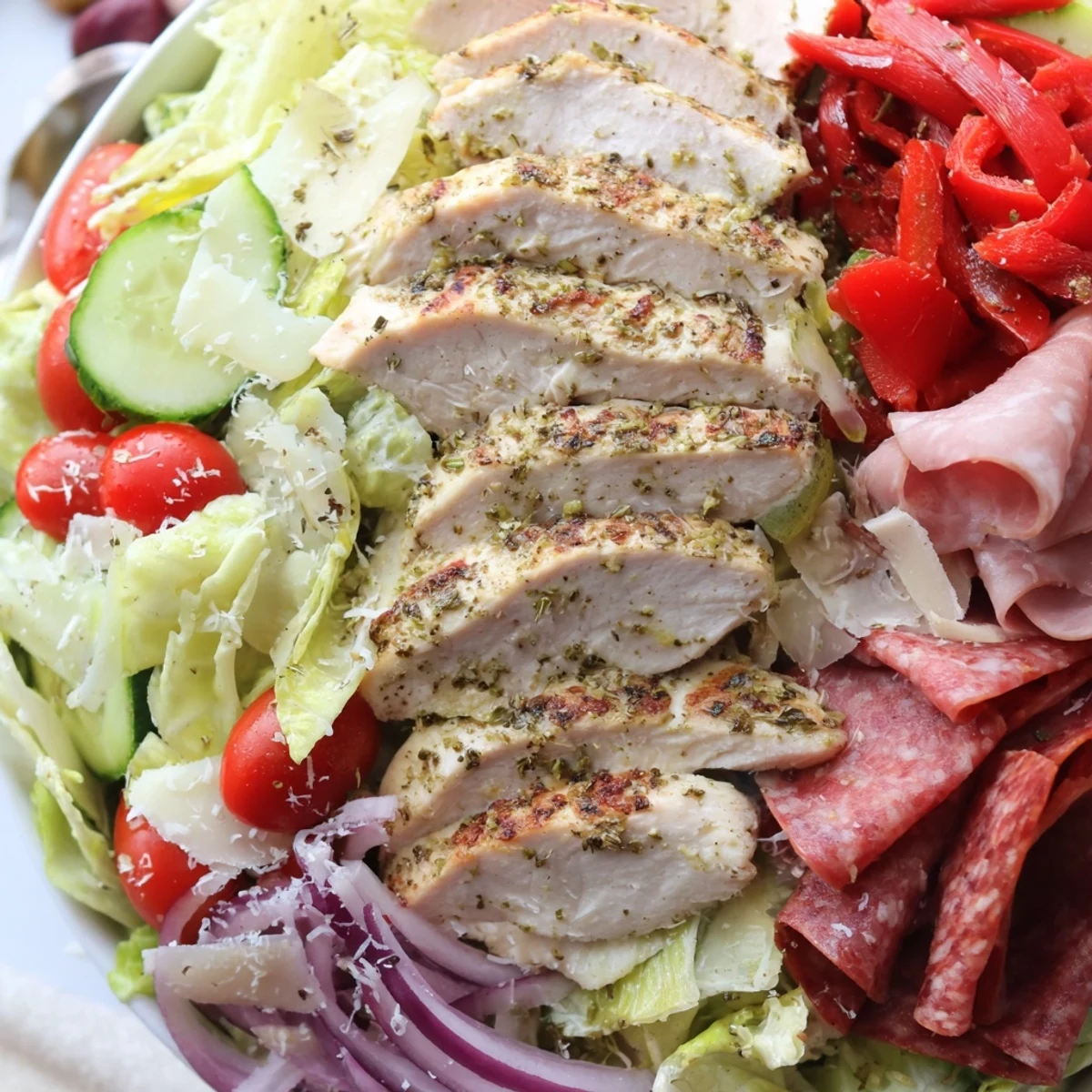 Hearty Italian Grinder Chicken Salad topped with juicy grilled chicken, fresh romaine, and zesty vinaigrette