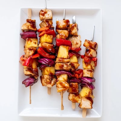 Golden pineapple chunks and tender chicken pieces on a skewer ready to serve.