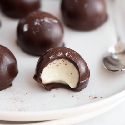 Warm spiced Dark Chocolate Eggnog Truffles sitting beside cocktail napkins, holiday ready.