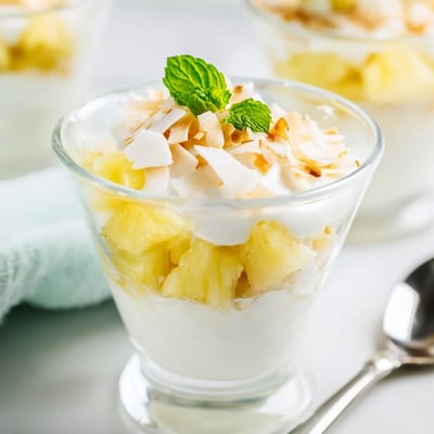 Chilled mini pineapple condensed coconut milk served in small glasses with fresh mint garnish